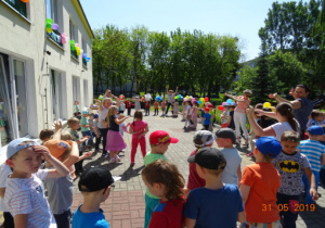 Wszystkie przedszkolaki tańczą na tarasie przedszkolnym.